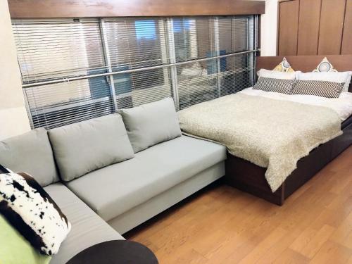 sala de estar con sofá y ventana grande en Ito Building 1st floor B, 2nd floor, 3rd floor - Vacation STAY 50412v, en Tokio