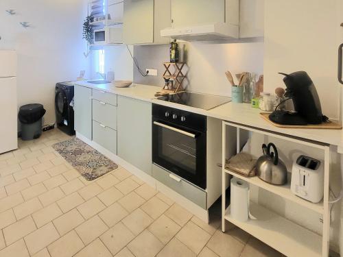 une cuisine avec une cuisinière et un comptoir dans l'établissement Appartement avec son toit terrasse, en plein coeur de Marseille, à Marseille