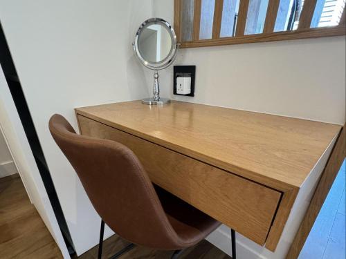 a dressing table with a mirror and a chair at Bree Street Apartment - Explore, Eat, Experience Cape Town in Cape Town