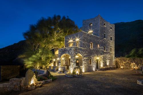 a large stone building with lights on it at night at Porto Kale Guesthouse in Porto Kagio