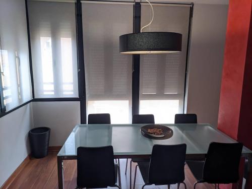 a dining room with a glass table and chairs at Casa del Doctor in Seville