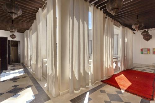 a hallway with large windows and a red rug at Riad Palais Bahia Fes in Fès