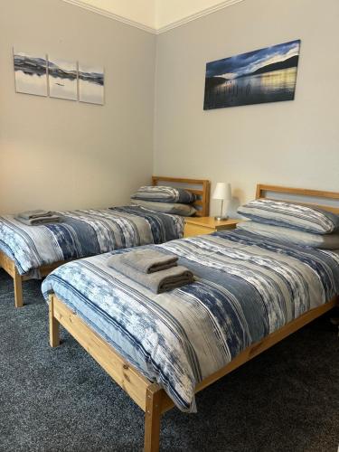 een kamer met drie bedden in een kamer bij Hayfield Apartment in Oban