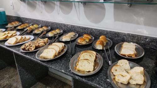 a bunch of sandwiches on plates on a counter at Hotel Por do Sol Polonini in Piúma