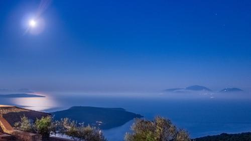luna llena sobre el océano por la noche en Heliopetra Luxury Villa Lefkas, en Vasiliki