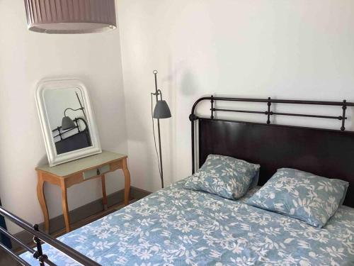a bedroom with a bed and a mirror and a lamp at Bellevue in Treignac