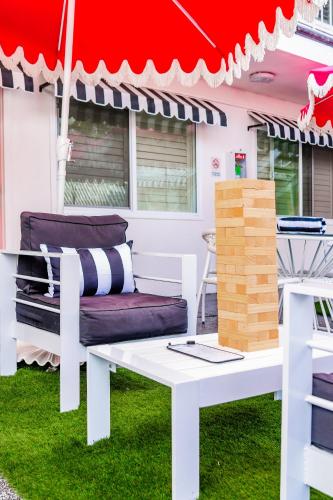 a white table and a bench under a red umbrella at Santa Monica Hotel in Los Angeles