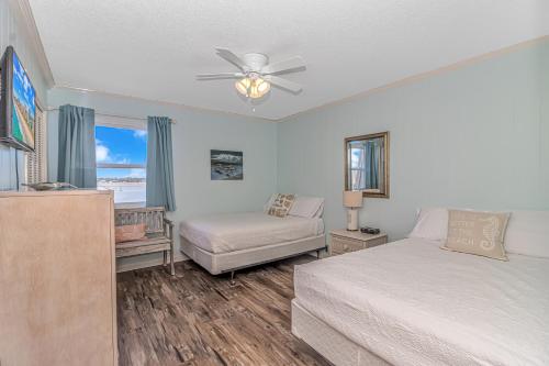 a bedroom with a bed and a couch and a window at Salty Dogs - Gated, Private Dock, Beach Access in Myrtle Beach