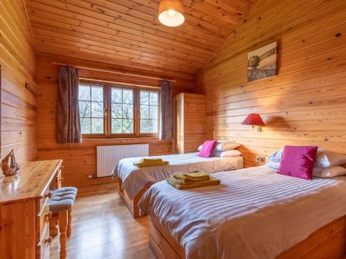 um quarto com 2 camas num chalé de madeira em 4 Bed in Clovelly 00360 em Clovelly