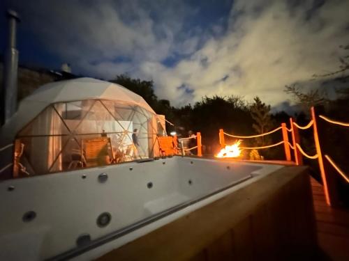 une yourte avec un feu en arrière-plan la nuit dans l'établissement Sky Lodge Domes Cusco, à Cusco