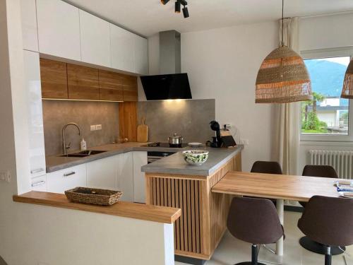 a kitchen with a counter and a table with chairs at Villa Mazzano in Riva del Garda