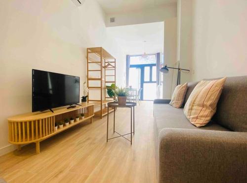 a living room with a couch and a flat screen tv at Nice & Cozy Flat Close The Beach in Valencia