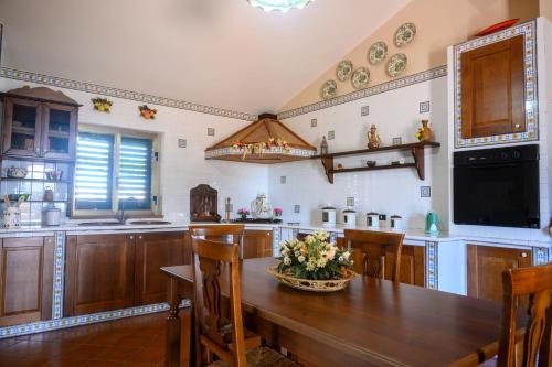 a kitchen with a wooden table with flowers on it at Country Sicily Home in Favara
