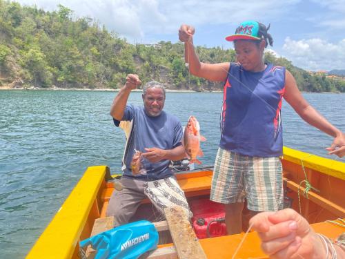 two men on a boat holding a fish at Triple Room Bed and Breakfast main House in Guillet