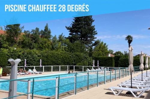 a pool at a resort with chaise lounge chairs at Caprozion-Erosoa-T1-Piscine-Clim in Ciboure