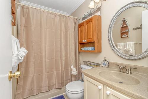 a bathroom with a toilet and a sink and a mirror at Fishing Dock, Trailer Parking, Gated, Beach Access in Myrtle Beach