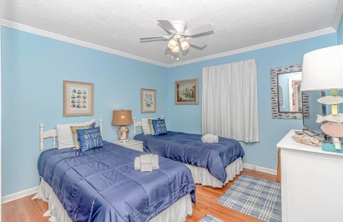 a blue bedroom with two beds and a ceiling fan at Fishing Dock, Trailer Parking, Gated, Beach Access in Myrtle Beach