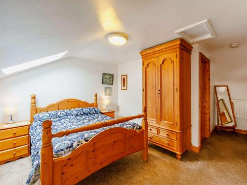 a bedroom with a wooden bed and a wooden cabinet at 2 bed in Appleby 87537 in Long Marton