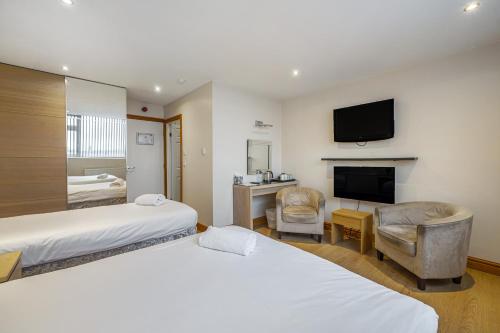 a hotel room with two beds and a flat screen tv at Bluewaters Hotel Blackpool in Blackpool