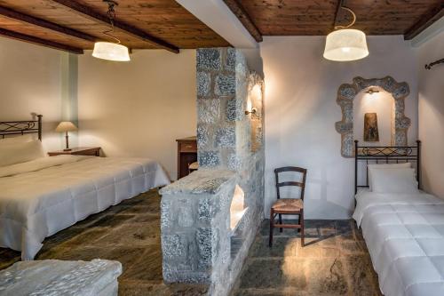 a bedroom with two beds and a chair and a mirror at Porto Kale Guesthouse in Porto Kagio
