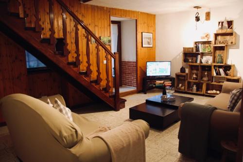 uma sala de estar com um sofá e uma televisão em Cà Mia em Nus