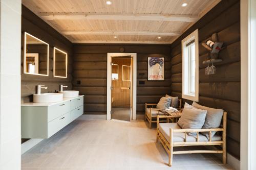 a bathroom with wooden walls and a sink and chairs at Åre Valley Lodges - Grand Ski Lodge in Åre