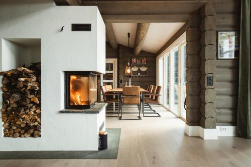 un salon avec une cheminée et une salle à manger dans l'établissement Åre Valley Lodges - Grand Ski Lodge, à Åre