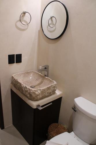a bathroom with a marble sink and a mirror at Casa Las Palmas Holbox in Holbox Island