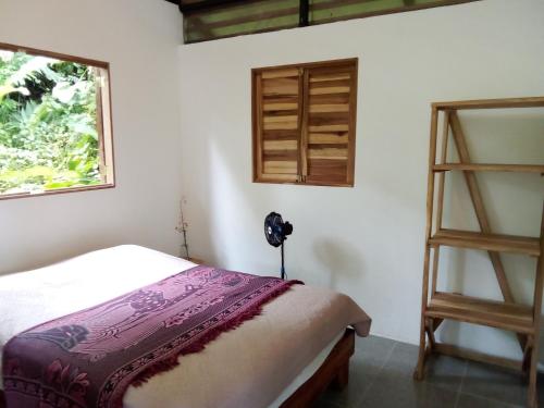 1 dormitorio con cama y estante para libros en Almendra de Montaña en Puerto Viejo