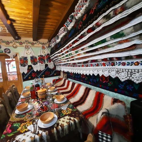 a dining room with a long table with plates of food at Pensiunea Codrea - Wagner in Lazu Baciului