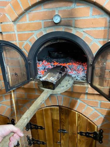 a brick oven with a pizza inside of it at Pensiunea Codrea - Wagner in Lazu Baciului
