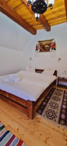 a wooden bed in a room with a ceiling at Pensiunea Codrea - Wagner in Lazu Baciului