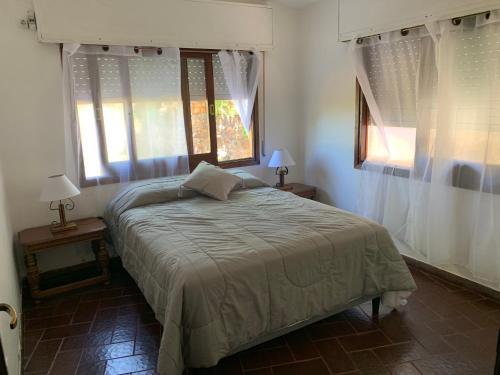 1 dormitorio con 1 cama y 2 ventanas en Coco del este, en Punta del Este