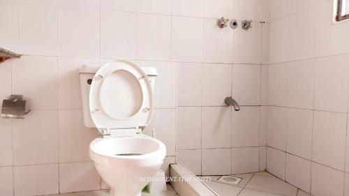 een badkamer met een toilet met de bril omhoog bij Two Bedroom Nyali, City Mall in Mombasa