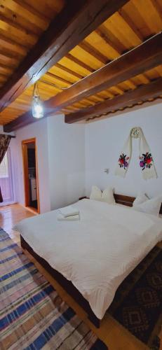 a bedroom with a large white bed in a room at Pensiunea Codrea - Wagner in Lazu Baciului
