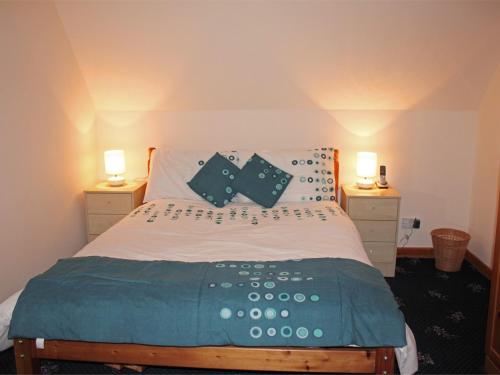 a bedroom with a bed with two night stands and two lamps at 3 Bed in Isle of Barra CA295 in Ersary