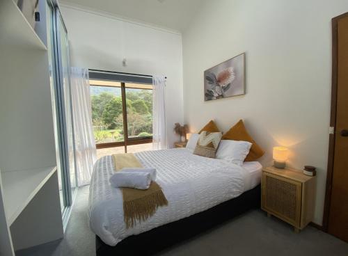 sypialnia z łóżkiem i dużym oknem w obiekcie Riverlin Estate w mieście Warburton