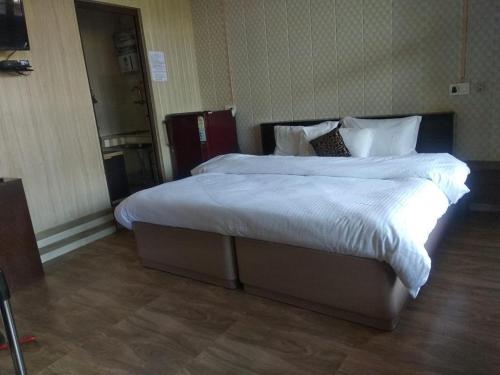 a bedroom with a large bed with white sheets and pillows at Oxygen Homestay-A Blissful Retreat in Dehradun