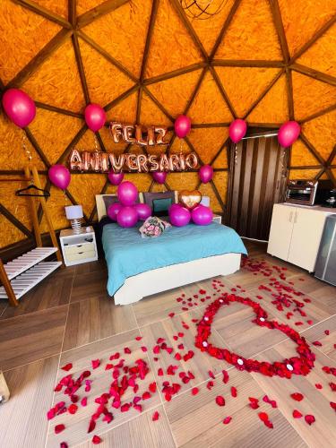 a room with a bed in a yurt with red flowers at Glamping Monteverde San gil in San Gil