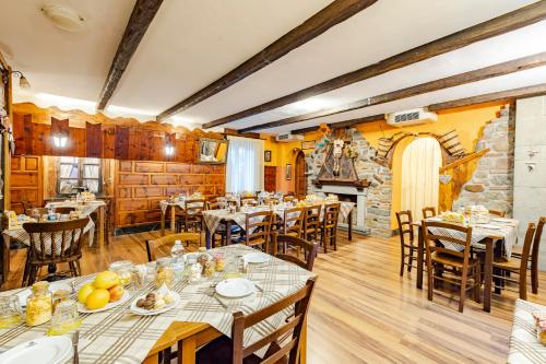 a restaurant with tables and chairs and a fireplace at Hotel&Restaurant Armanac de Toubïe in Arnad
