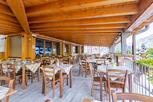 a restaurant with wooden ceilings and tables and chairs at Hotel&Restaurant Armanac de Toubïe in Arnad