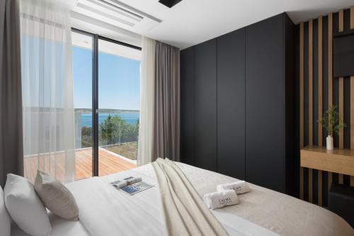 a bedroom with a large bed and a large window at 5-Star Villa Calma II with Heated Pool & Jacuzzi Oasis in Starigrad-Paklenica
