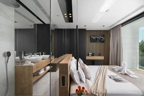 a bathroom with a king sized bed and a sink at 5-Star Villa Calma II with Heated Pool & Jacuzzi Oasis in Starigrad-Paklenica