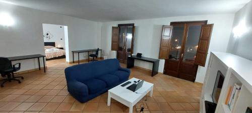 een woonkamer met een blauwe bank en een tafel bij Casa Santa Lucia in Cosenza