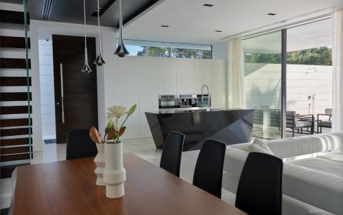 a kitchen and dining room with a table and a couch at 5-Star Villa Calma II with Heated Pool & Jacuzzi Oasis in Starigrad-Paklenica