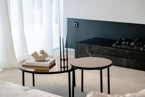 a living room with a table and a stool and a couch at 5-Star Villa Calma II with Heated Pool & Jacuzzi Oasis in Starigrad-Paklenica