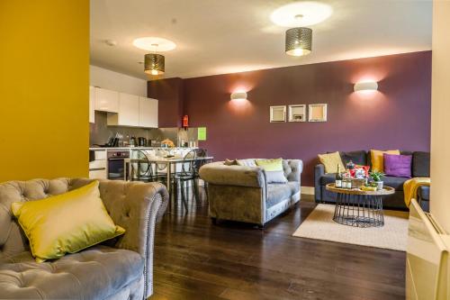 a living room with two couches and a kitchen at Luxurious & Spacious Apartment in Reading