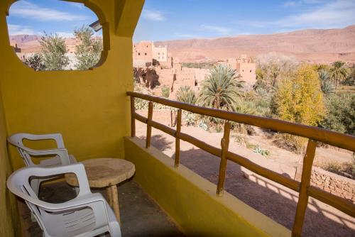 a balcony with a table and chairs and a view of the desert at Kasbah Omari in Tinerhir