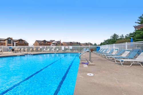 a large swimming pool with blue water and chairs at Tigers Den - Upper in Arkdale