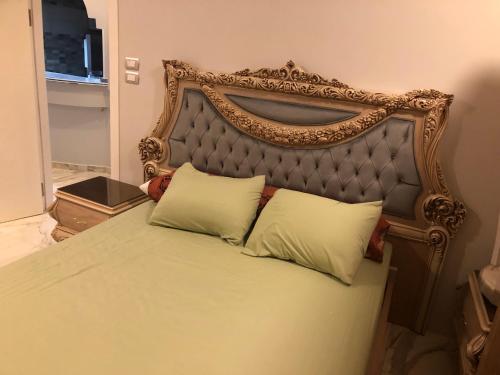 a bed with a ornate headboard and two pillows at New Villa Carimo in Quseir